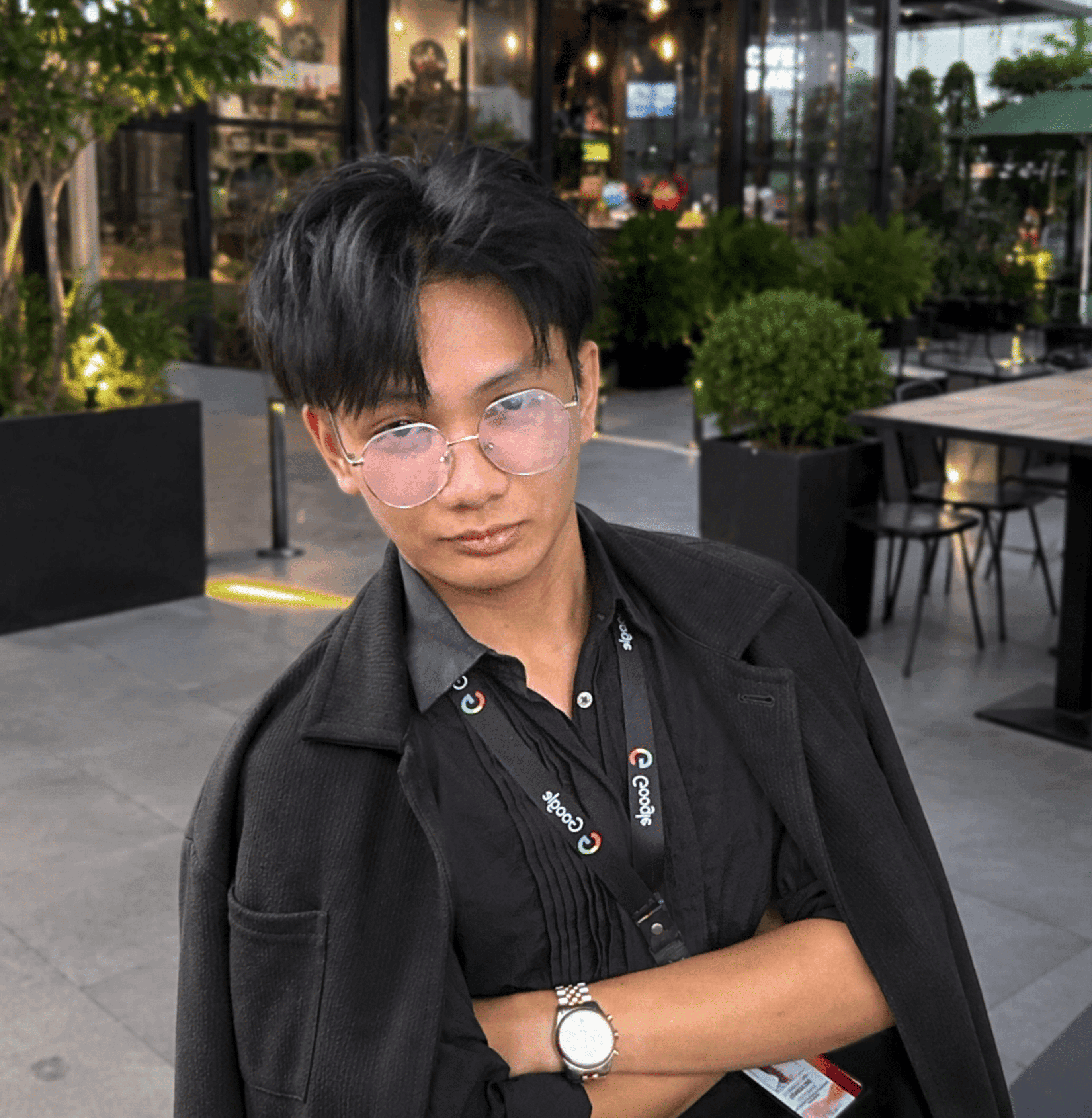 Portrait of Vince Gabriel Deligente wearing glasses and a dark jacket, seated outdoors.